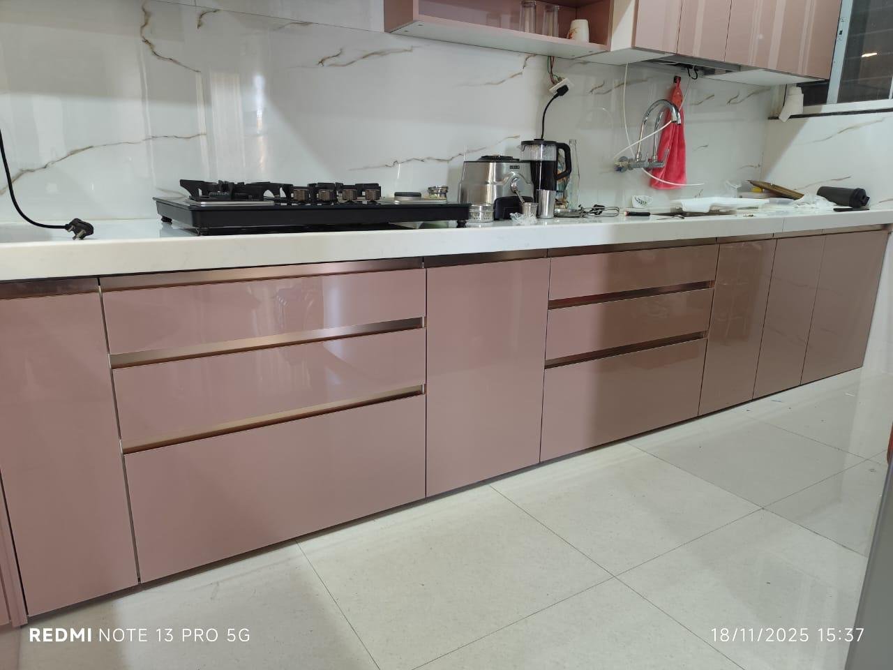 Modular kitchen in glossy rose with a marble-look backsplash