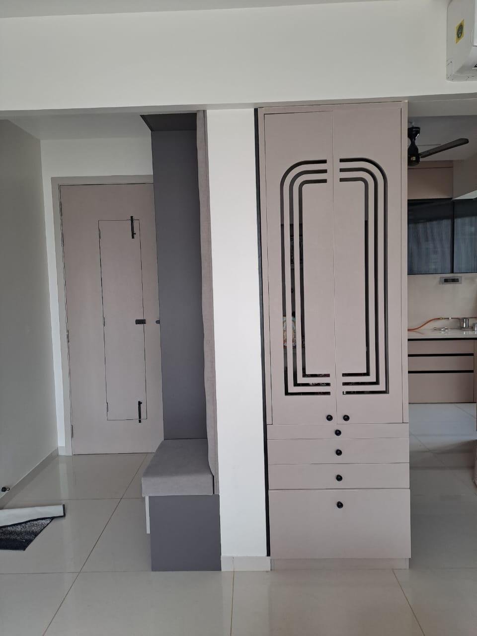 Mandir cabinet with cut-out doors and drawers alongside an entryway bench unit