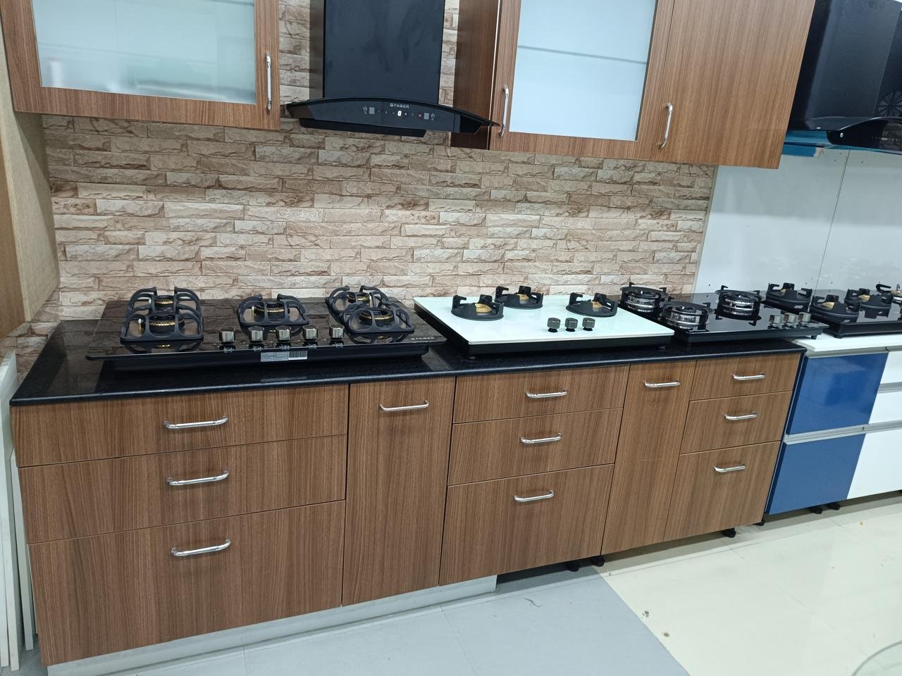 Kitchen cabinets in wood-finish laminate with a stacked stone backsplash