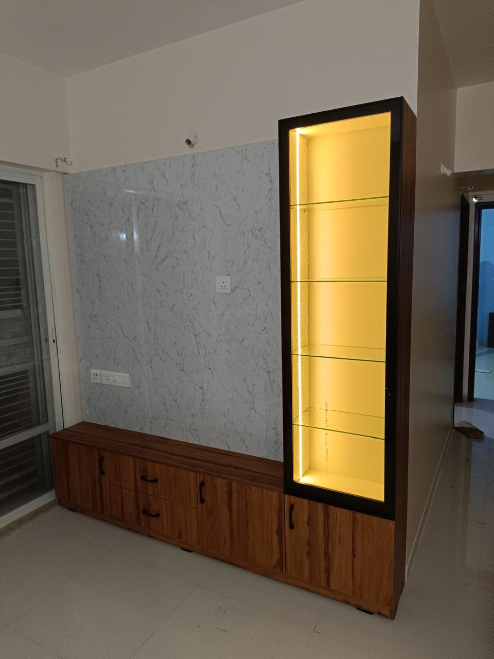Hallway TV console with an illuminated glass display tower
