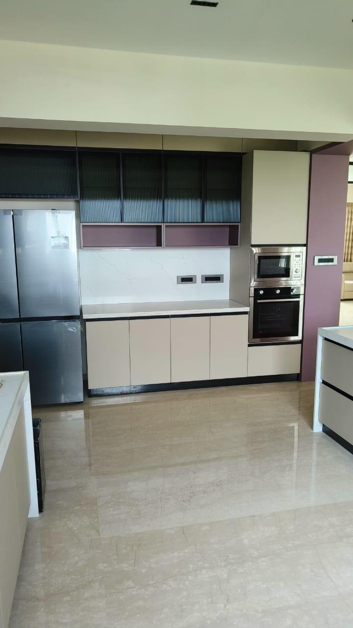 Modular kitchen in beige with fluted glass upper cabinets and a built-in oven column